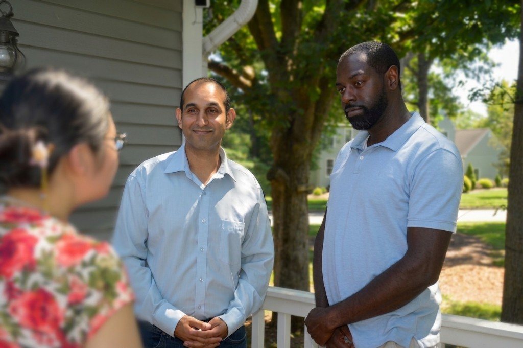 Inderpreet Banga and Eugene Tawiah talking with a neighbor